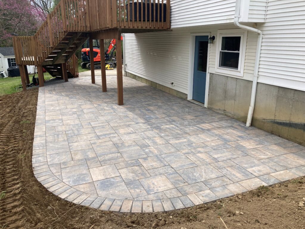 Beautiful stone patio wrapping around back of house Cranehill Contracting Cranehill Contracting by Cranehill Contracting