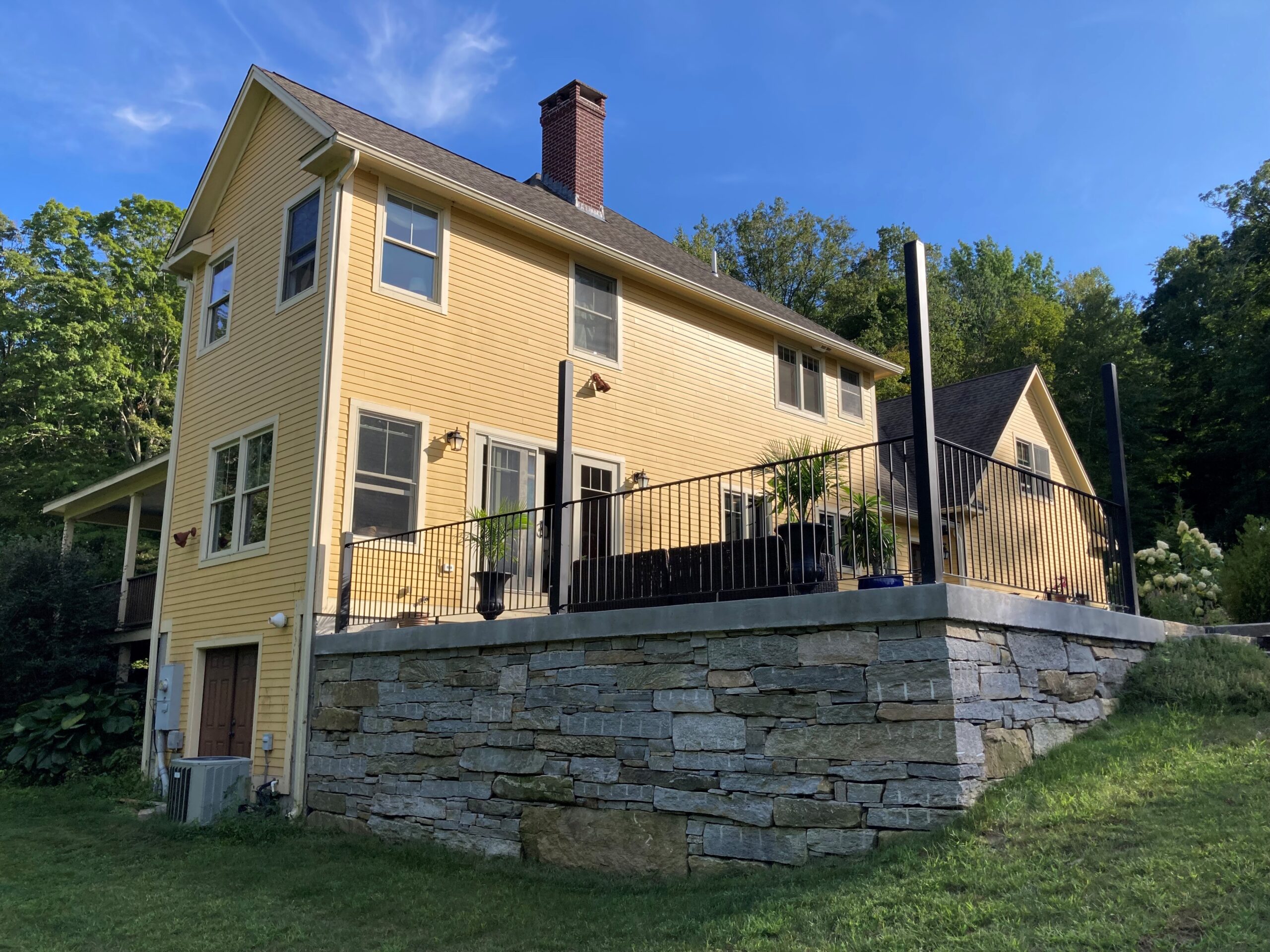 Gorgeous stone patio and wall for a deck by Cranehill Contracting
